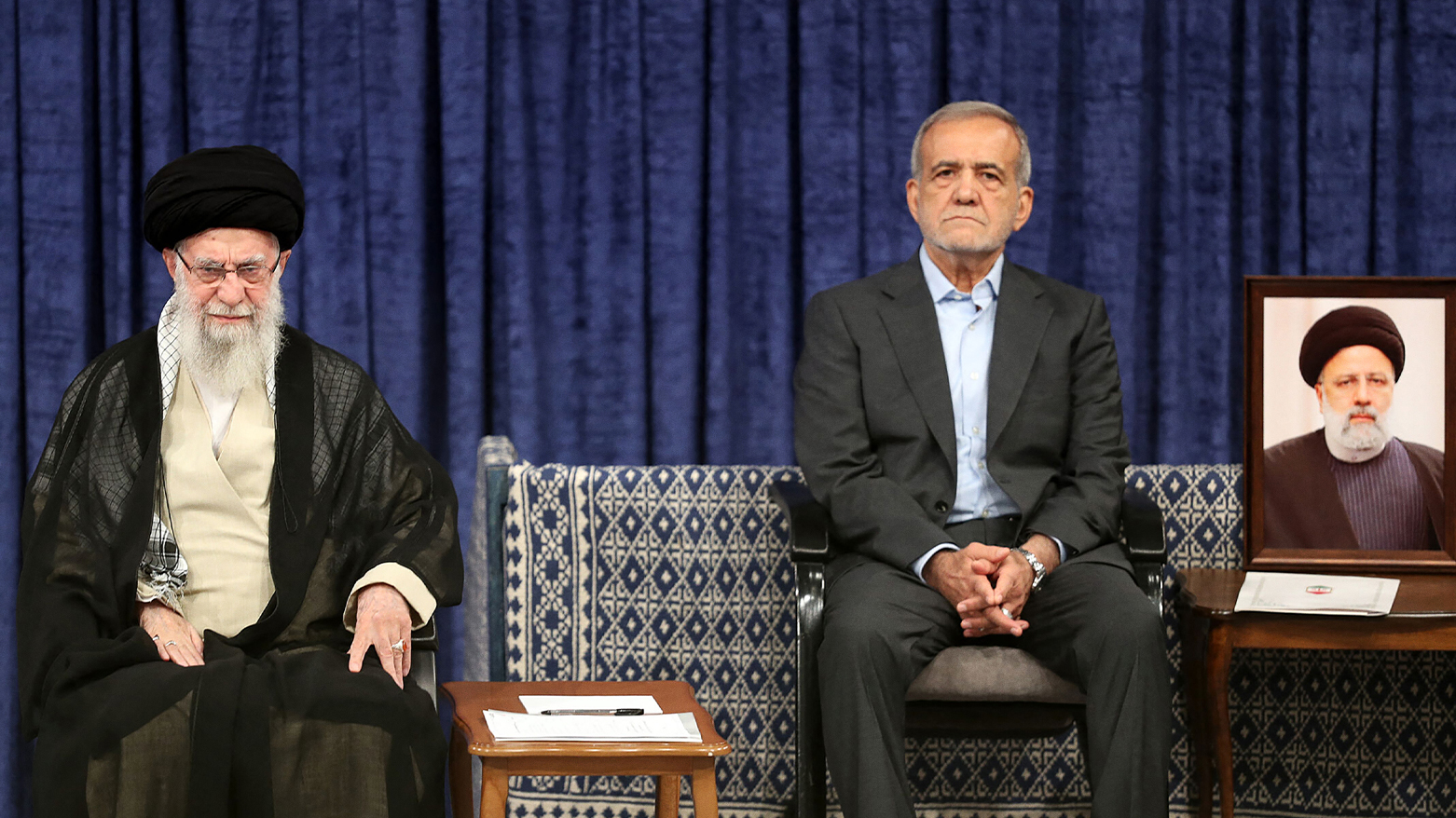 Iranian supreme leader Ayatollah Ali Khamenei (L), and president elect Masoud Pezeshikan (R) sitting next to a portrait of the late Iranian president Ebrahim Raisi. (Photo: AFP)