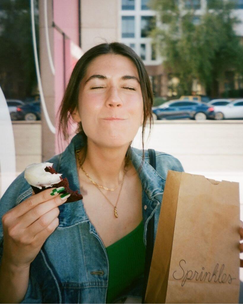 picture of a girl eating a cupcake in front of sprinkles cupcake scottsdale