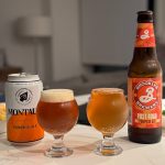 Two glasses on a table, left filled with Montauk Pumpkin Ale showing a darker hue and creamier head, right filled with Brooklyn Brewery Post Road Pumpkin Ale, lighter in color.