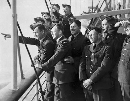 Troops aboard a boat point to the shore