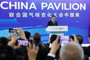 A man speaks at China Pavilion with crowds taking photos of him