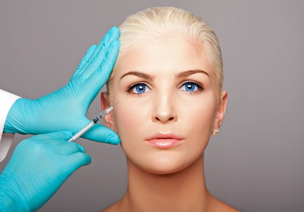 Cosmetic plastic surgeon injecting restylane under eye