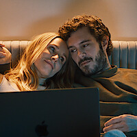 Kristen Bell as Joanne and Adam Brody as Noah snuggle on a couch together in Season 1 of 'Nobody Wants This'