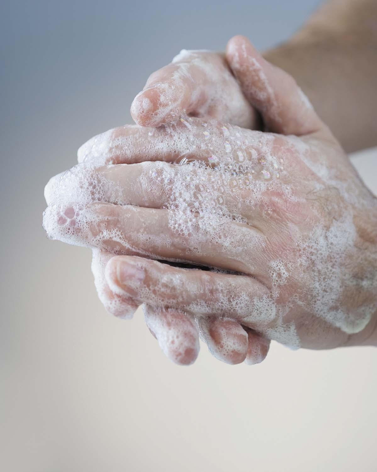 Cropped photo of soapy hands in mid-wash.