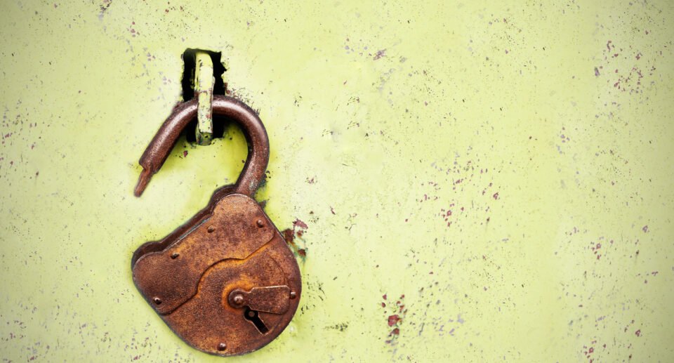 Old rusty lock without a key on a blue background