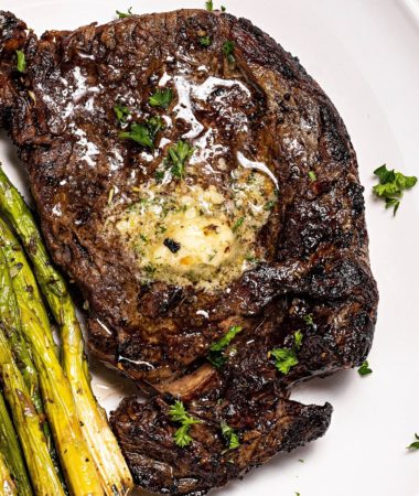 close up of Ninja Foodi air fryer steak on a plate with air fryer asparagus