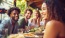 a group of people sitting at a table with food