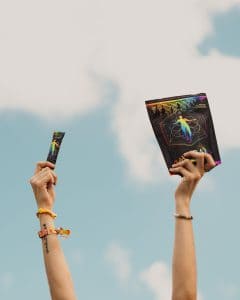 Two hands holding up a book and a paper.