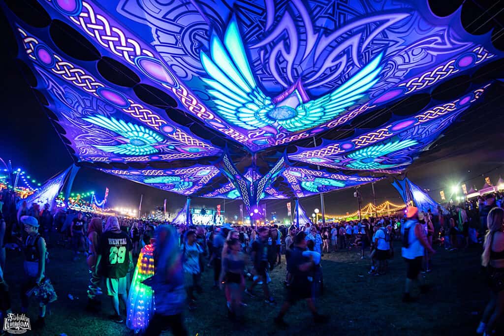 A crowd of people standing under an illuminated ceiling.