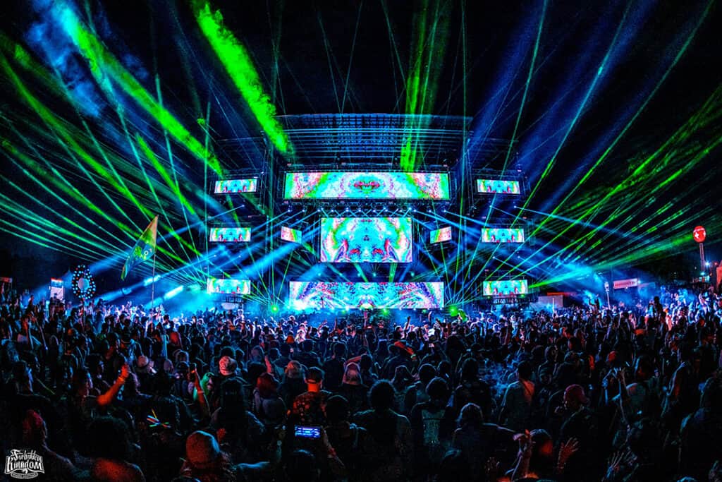 A crowd of people in front of a stage with lights.