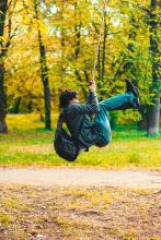 person swinging on a rope swing in the woods