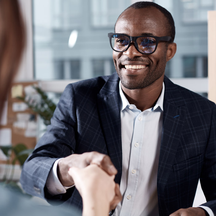 two people shaking hands in an interview setting