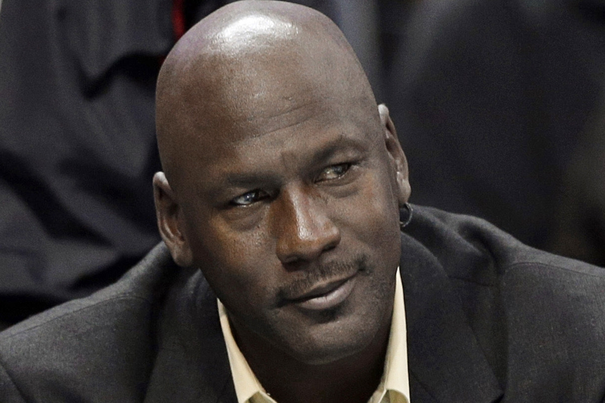 FILE - In this April 16, 2014, file photo, Charlotte Bobcats owner Michael Jordan watches an NBA basketball game between the Bobcats and the Chicago Bulls in Charlotte, N.C. The six-time NBA champion is scheduled to appear Tuesday, Aug. 11, 2015, in federal court in Chicago for the start of a civil trial and will later testify on the unauthorized use of his identity. A court already ruled a grocery-story chain used his identity without permission in a magazine ad and so the unresolved legal issue is damages. (AP Photo/Chuck Burton, File)