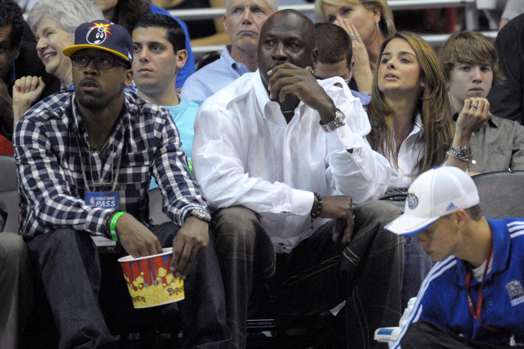 Charlotte Bobcats majority owner Michael Jordan, center, watches the second half of Game 2 of a first round NBA basketball playoff game between the Orlando Magic and the Charlotte Bobcats in Orlando, Fla., Wednesday, April 21, 2010. Sitting next to him are his son, Marcus Jordan, left, and Yvette Prieto, right.