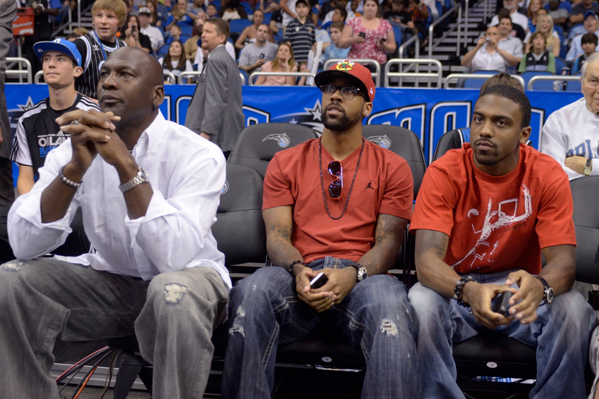 Michael Jordan watches a basketball game with his sons Marcus, center, and Jeffrey