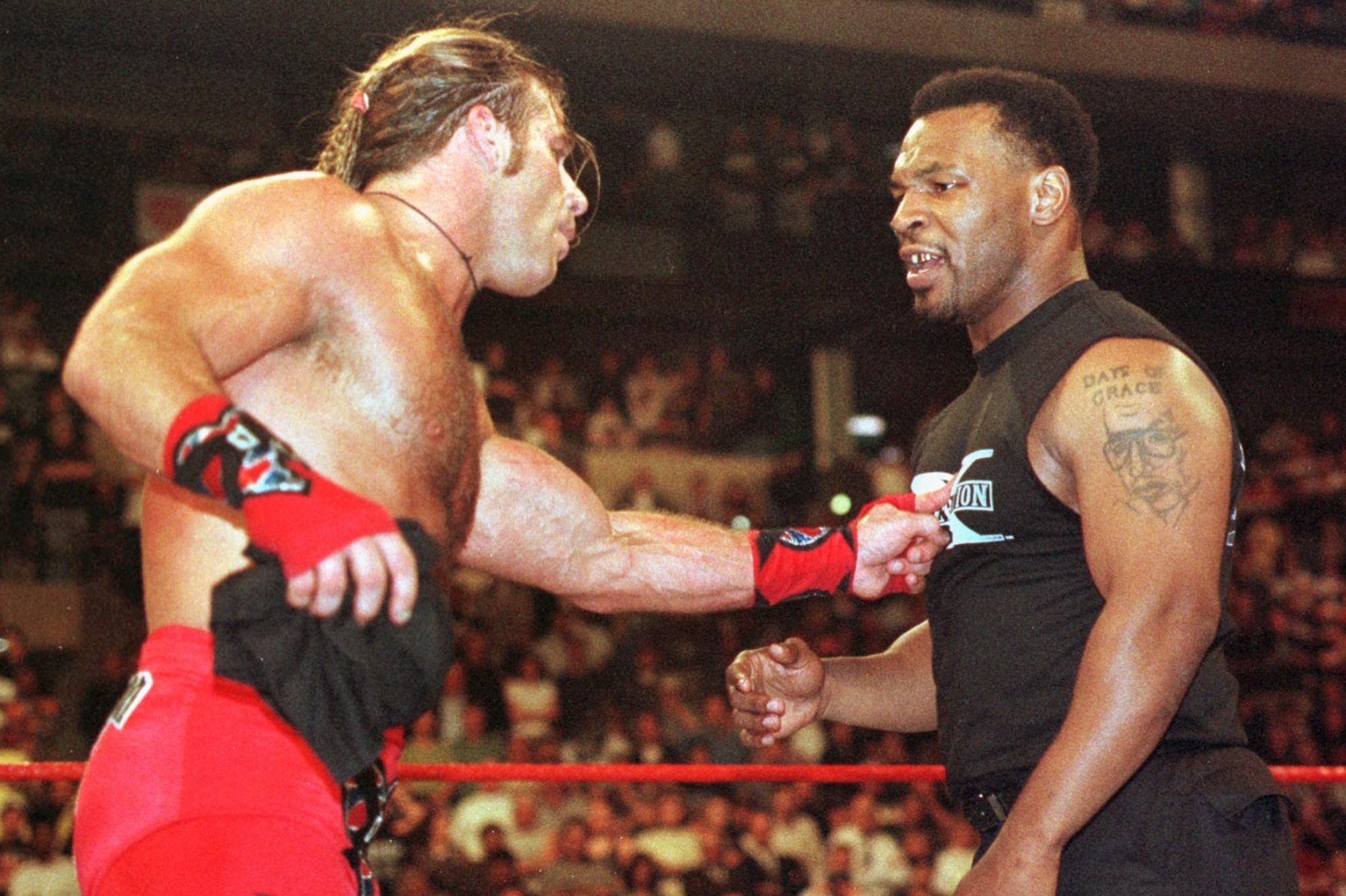 Former Heavyweight Champion Boxer Mike Tyson, right, gets a finger in the chest from wrestler Shawn Michaels during Wrestlemania XIV in Boston Sunday, March 29, 1998. Tyson, the former heavyweight boxing champion, serving as ``a special enforcer for the World Wrestling Federation championship match between Michaels and challenger Stone Cold Steve Austin at the FleetCenter