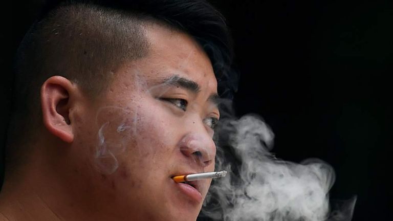 A young man smoking a cigarette outside a children's hospital in Beijing