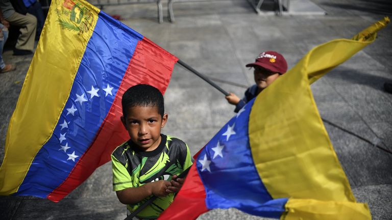 Children wave Venezuelan national flags, as supporters of Venezuelan President Nicolas Maduro gather at Bolivar square in Caracas 