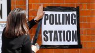 A woman attaches a sign on the wall of a polling station, during the local elections in London, Britain May 5, 2022. REUTERS/Peter Nicholls
