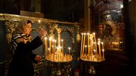 A woman places a candle during Christmas Eve service at St. Michael's Golden-Domed Cathedral, amid Russia's attack on Ukraine, in Kyiv, Ukraine, December 24, 2024. REUTERS/Thomas Peter

