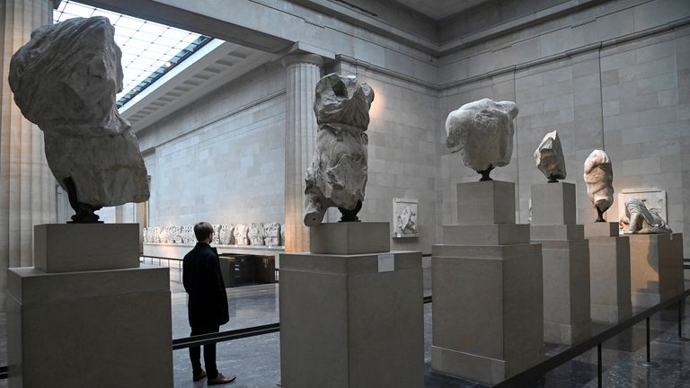 An employee poses as he views examples of the Parthenon sculptures, sometimes referred to in the UK as the Elgin Marbles, on display at the British Museum in London, Britain, January 25, 2023. REUTERS/Toby Melville