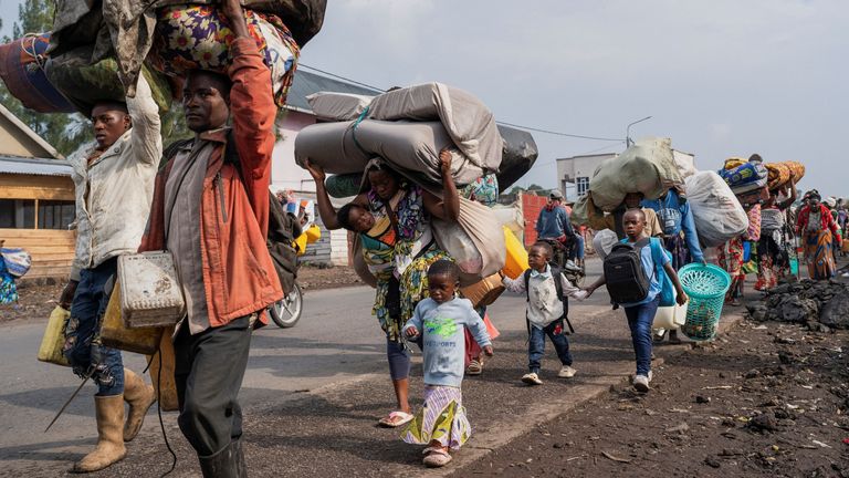 Internally displaced civilians carry their belongings as they flee the fight between M23 rebels and the Armed Forces of the Democratic Republic of the Congo (FARDC) on Sunday. Pic: Reuters