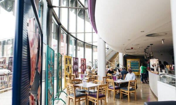 Cafe bar with full height glass windows down one side and a curved bar at the other