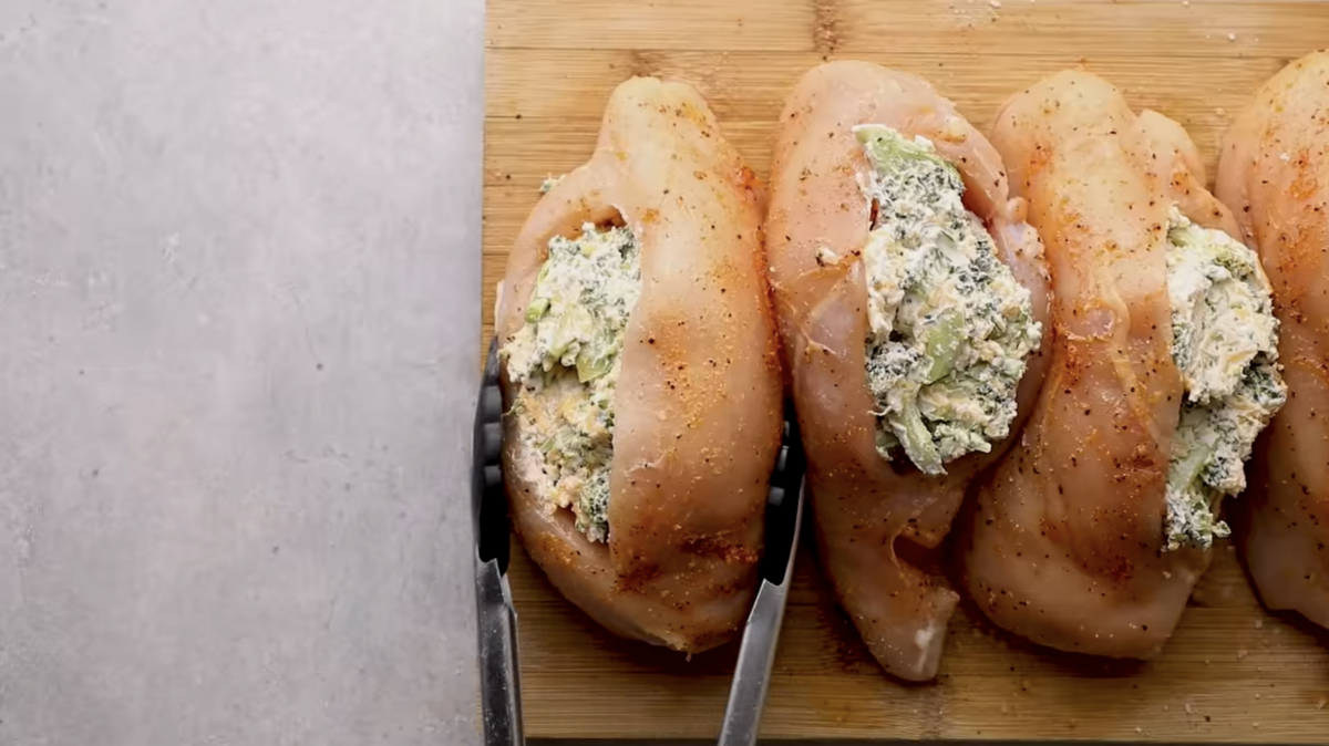 Raw chicken breasts stuffed with broccoli and cheese.