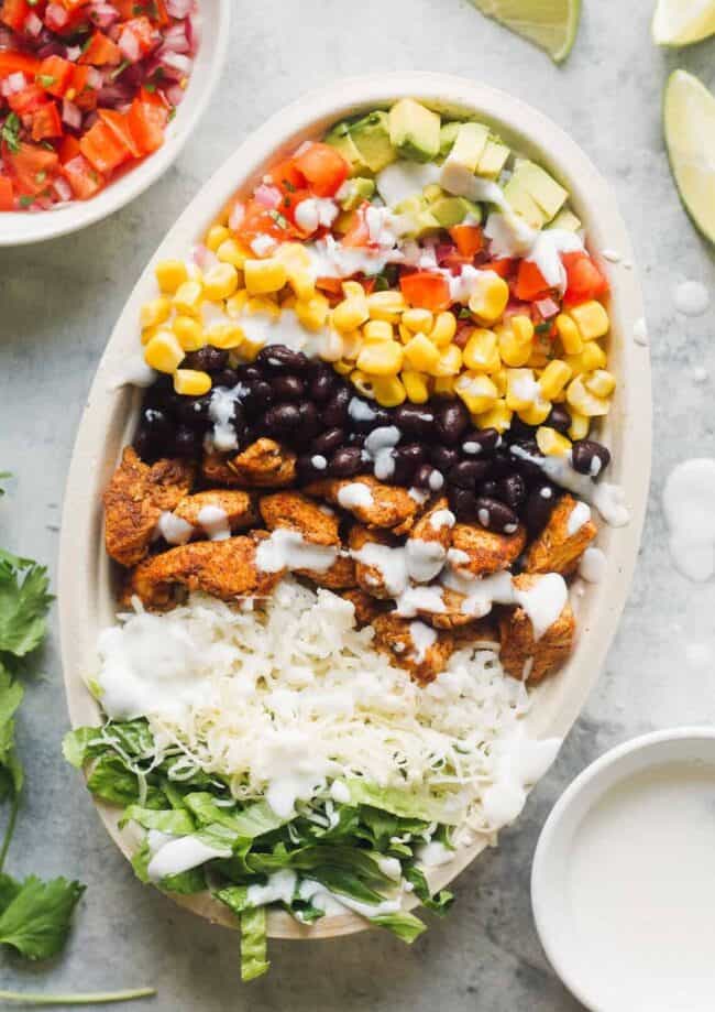 layered chicken burrito bowl next to ingredients