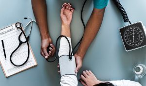 A health care worker takes a patient's blood pressure.