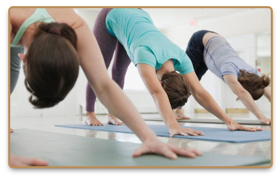 Group doing Hatha yoga exercises in yoga class on mats