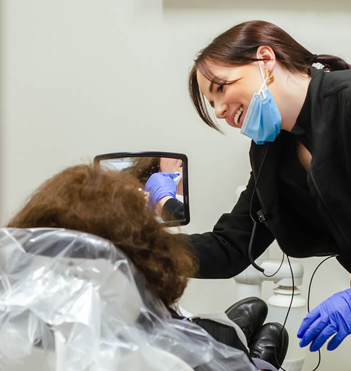 Hygienist showing patient her teeth