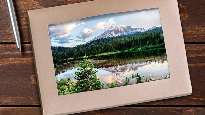 boxed set of greeting cards with a forest and mountain scene on the first card