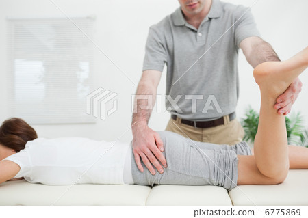 Stock Photo: Woman lying while being stretched by a doctor