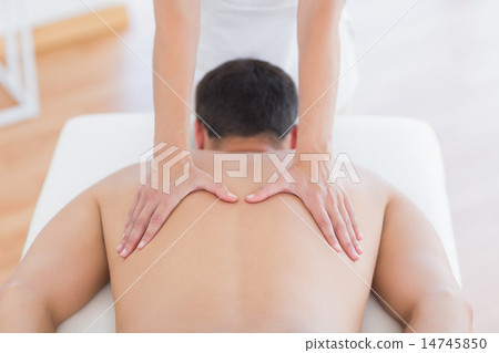 Stock Photo: Physiotherapist doing back massage to her patient