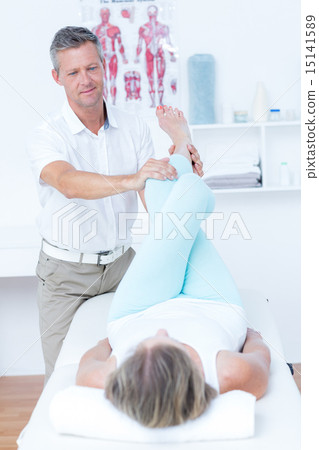 Stock Photo: Physiotherapist doing leg massage to his patient