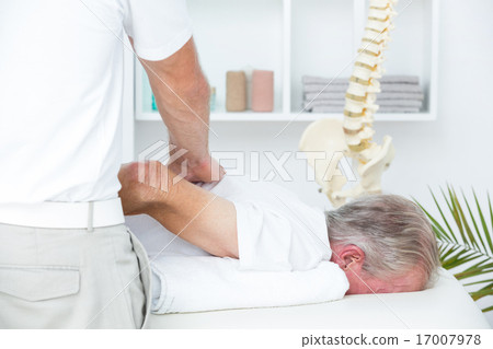 Stock Photo: Physiotherapist doing shoulder massage to his patient