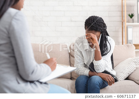 Depressed woman sitting on couch at psychotherapy session in coucellor's office 60671137