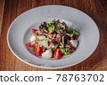 White Plate with Salad Stands on a Wooden Table in a Restaurant 78763702