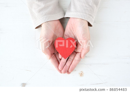 A woman holding a heart-shaped object 86854483