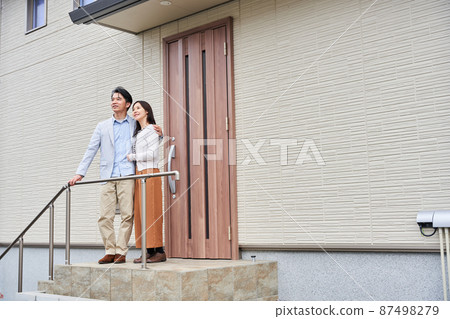 A couple standing in front of their home 87498279