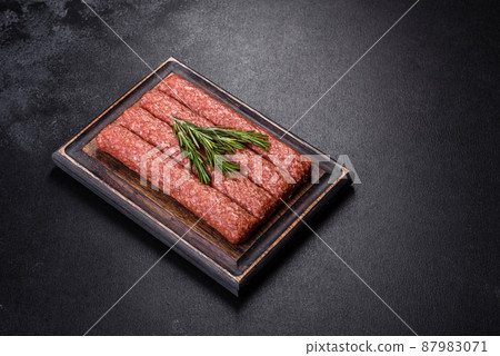 Fresh raw mince for grilled kebab with spices and herbs on a dark concrete background 87983071