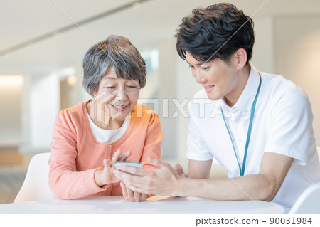 Senior female staff learning how to operate smartphones from young male staff "LINK FOREST" 90031984