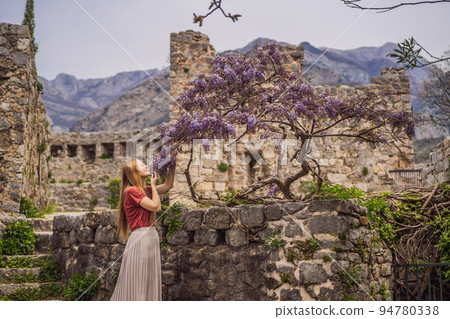 Woman tourist walks through the old town of Bar in Montenegro. Happy tourist walks in the mountains. Suburbs of the city of Bar, Montenegro, Balkans. Beautiful nature and landscape 94780338