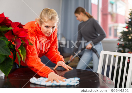 Mother and daughter cleaning room together before christmas 96644201