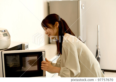 young asian woman using microwave 97757670