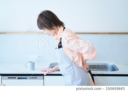 A woman in an apron with a stressed expression 100689665