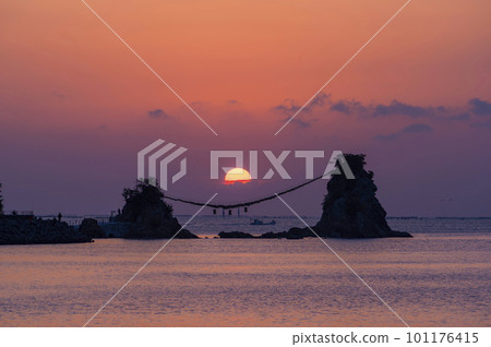 A large shimenawa rope and the first sunrise of a new year that connects the Meoto-iwa Rocks of Bungo Futamigaura in Saiki City, Oita Prefecture 101176415