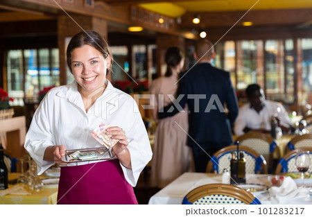 Happy woman waiter with good tip in restaurant 101283217