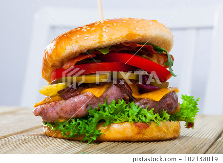 Double tasty hamburger with beef cutlet, fresh vegetables and cheese 102138019